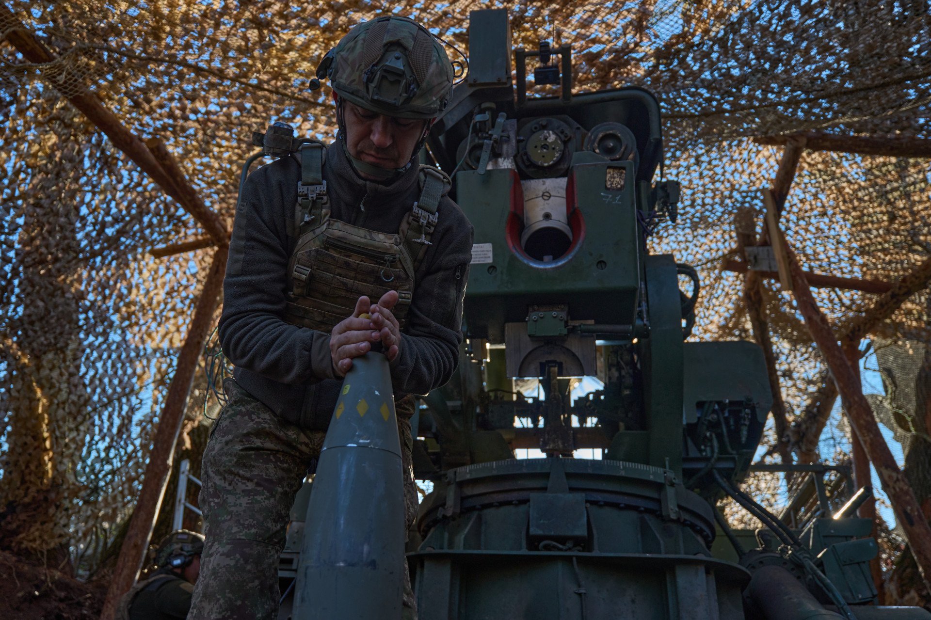 The loader of the Bohdana self-propelled artillery system prepares a shell for firing, carefully screwing in the fuse. The loader of the Bohdana self-propelled artillery system prepares a shell for firing, carefully screwing in the fuse.