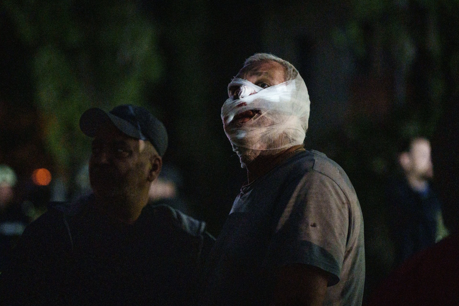 Bandaged and dazed, an injured man is helped away from the site of the missile strike. Dozens of others suffered similar wounds in the early-morning attack in Kyiv, Ukraine, on April 24, 2025. (Photo: Serhii Korovayny @serhiikorovayny)
