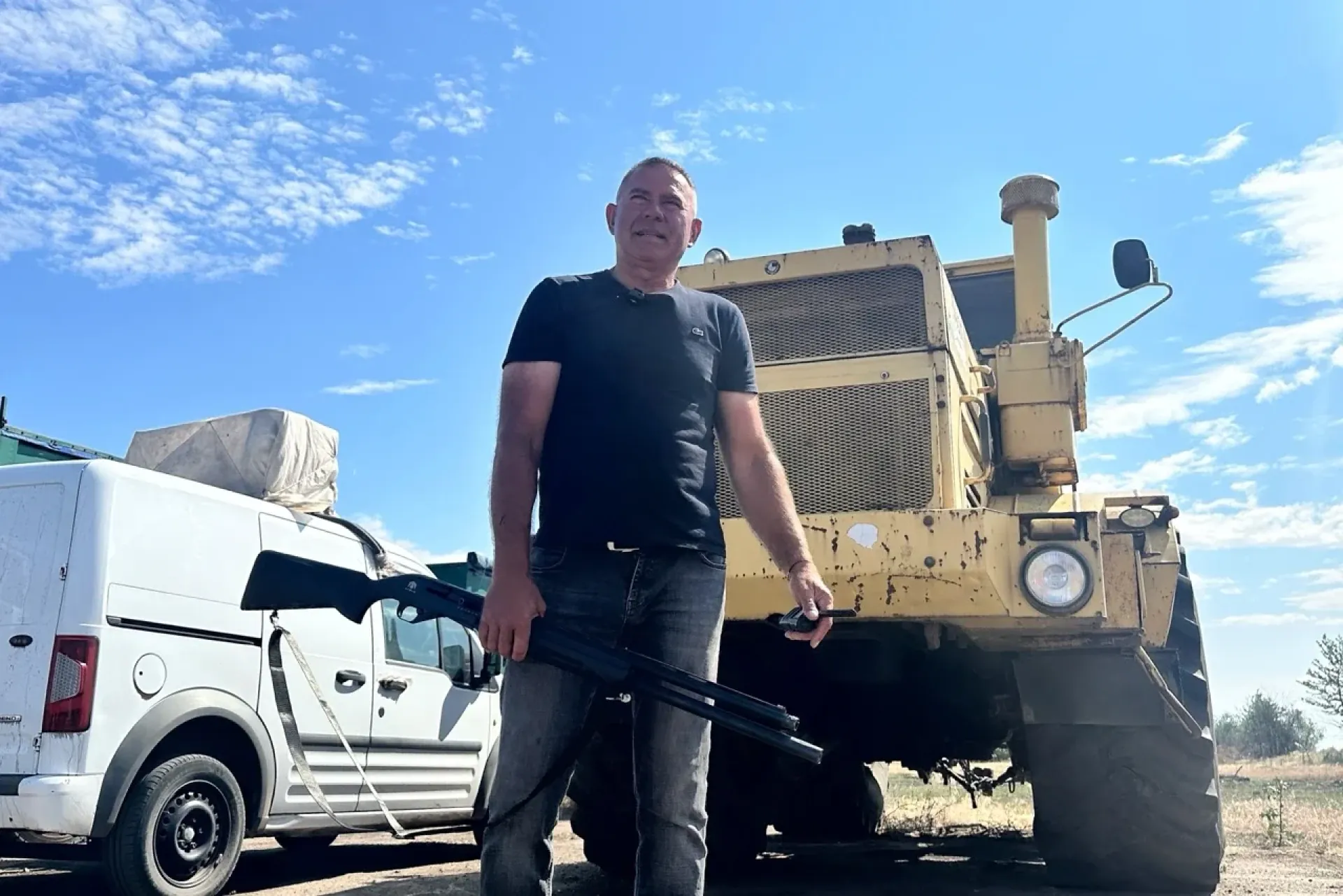 Olexandr Horodienko, Kherson farmer and regional council deputy, stands with a shotgun he used to protect his land from Russian drones. (Source: Most)