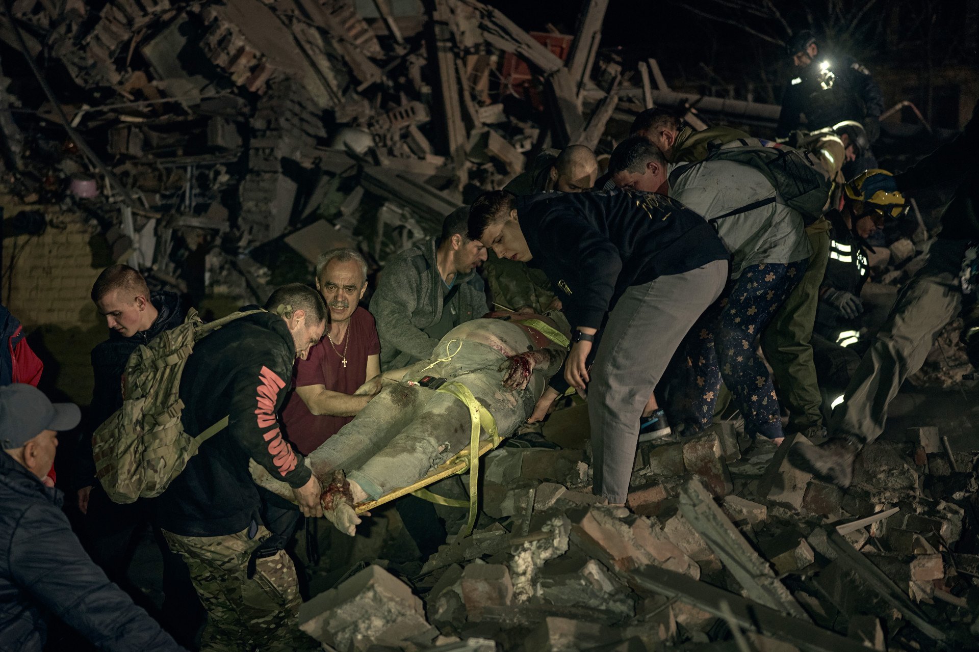 Neighbors and first responders rescue a pregnant woman buried under rubble. Russia’s strike killed 12 and injured dozens more, leaving families shattered on April 24, 2025 in Kyiv, Ukraine. (Photo: Kostiantyn Liberov/Libkos/Getty Images)