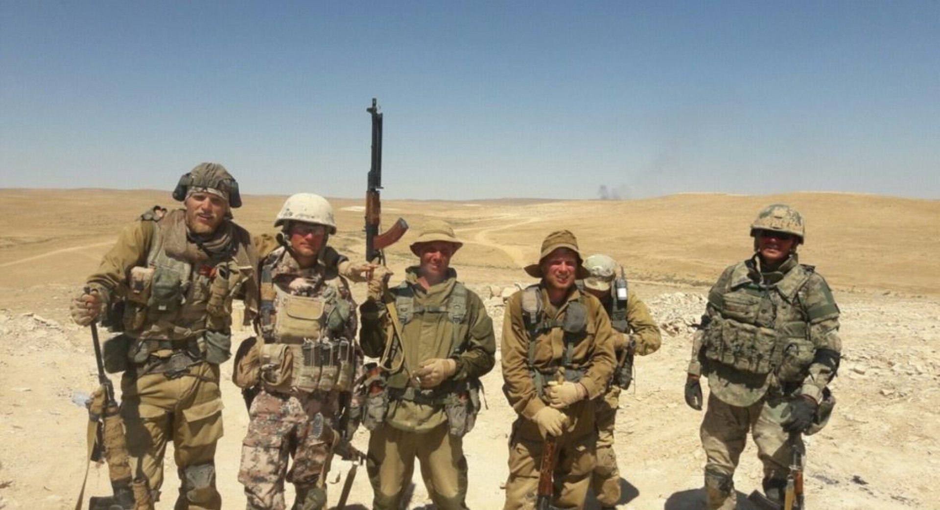 Presuntos miembros del Grupo Wagner posan para una foto en un paisaje desértico, vestidos con una mezcla de uniformes militares de estilo ruso y de Oriente Medio. (Fuente: medios rusos)
