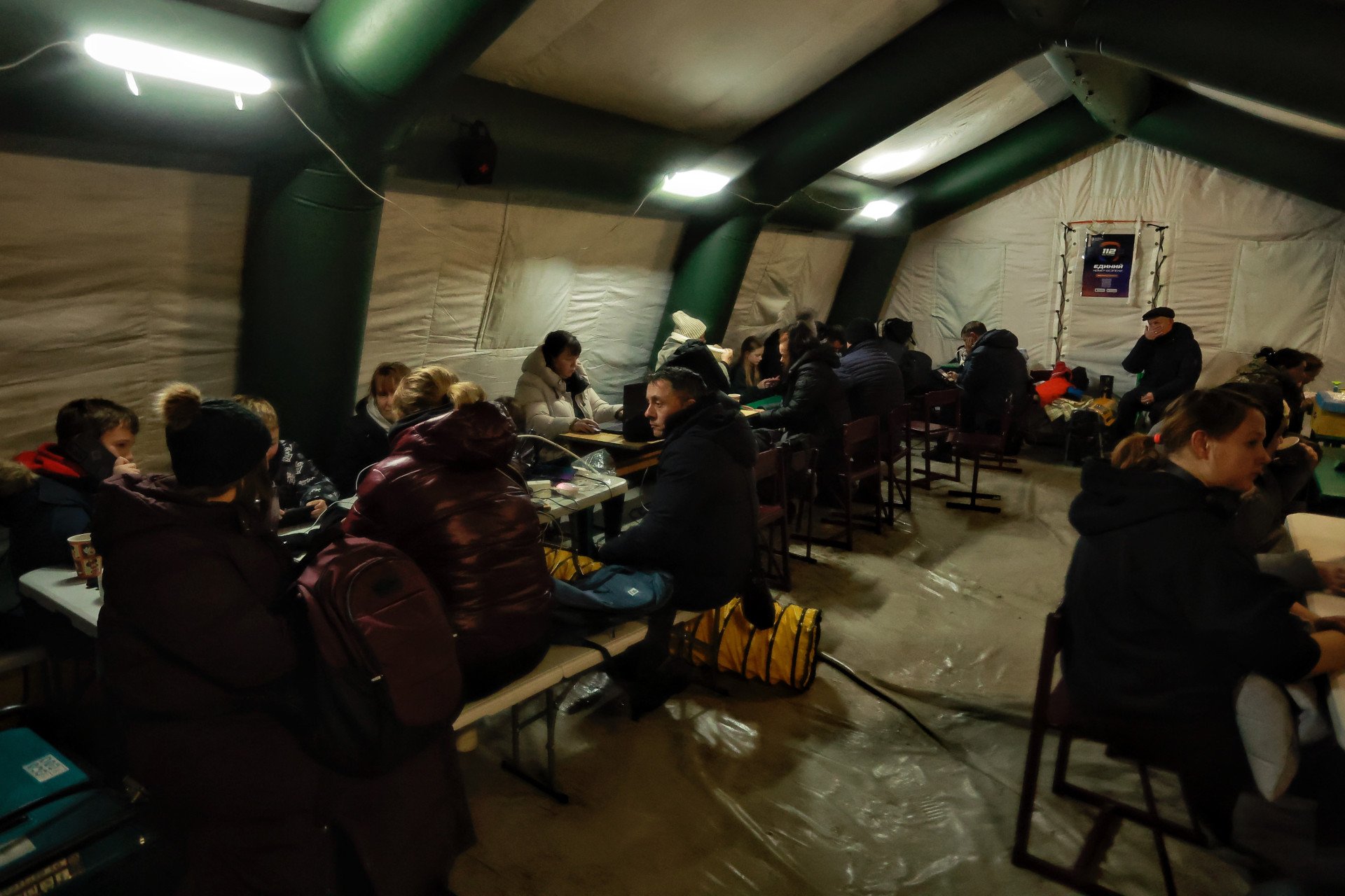 People charge devices, eat, and warm themselves at a mobile resilience hub in Kyiv on January 20, 2026, amid power and heating cuts caused by ongoing Russian missile and drone strikes. (Photo by Yan Dobronosov/Global Images Ukraine via Getty Images)