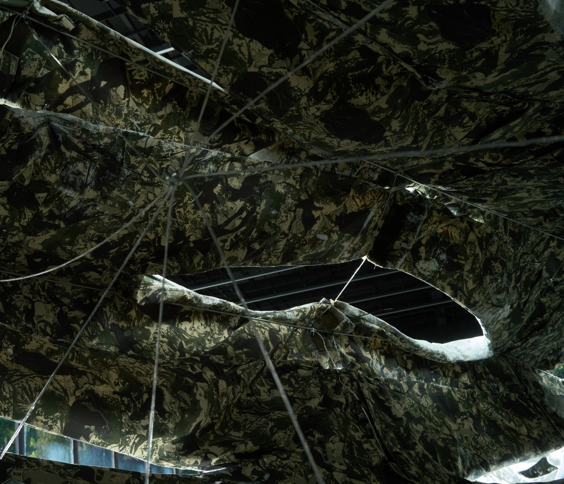 The underside of the white-painted camo uniforms, patterned after the markings of rescued cats, from the installation Three Perfectly Proportioned Spheres and Camouflage Uniforms Painted White, on September 14 at the Kyiv Pavilion of Culture. (Source: UNITED24 Media/Joshua Olley)