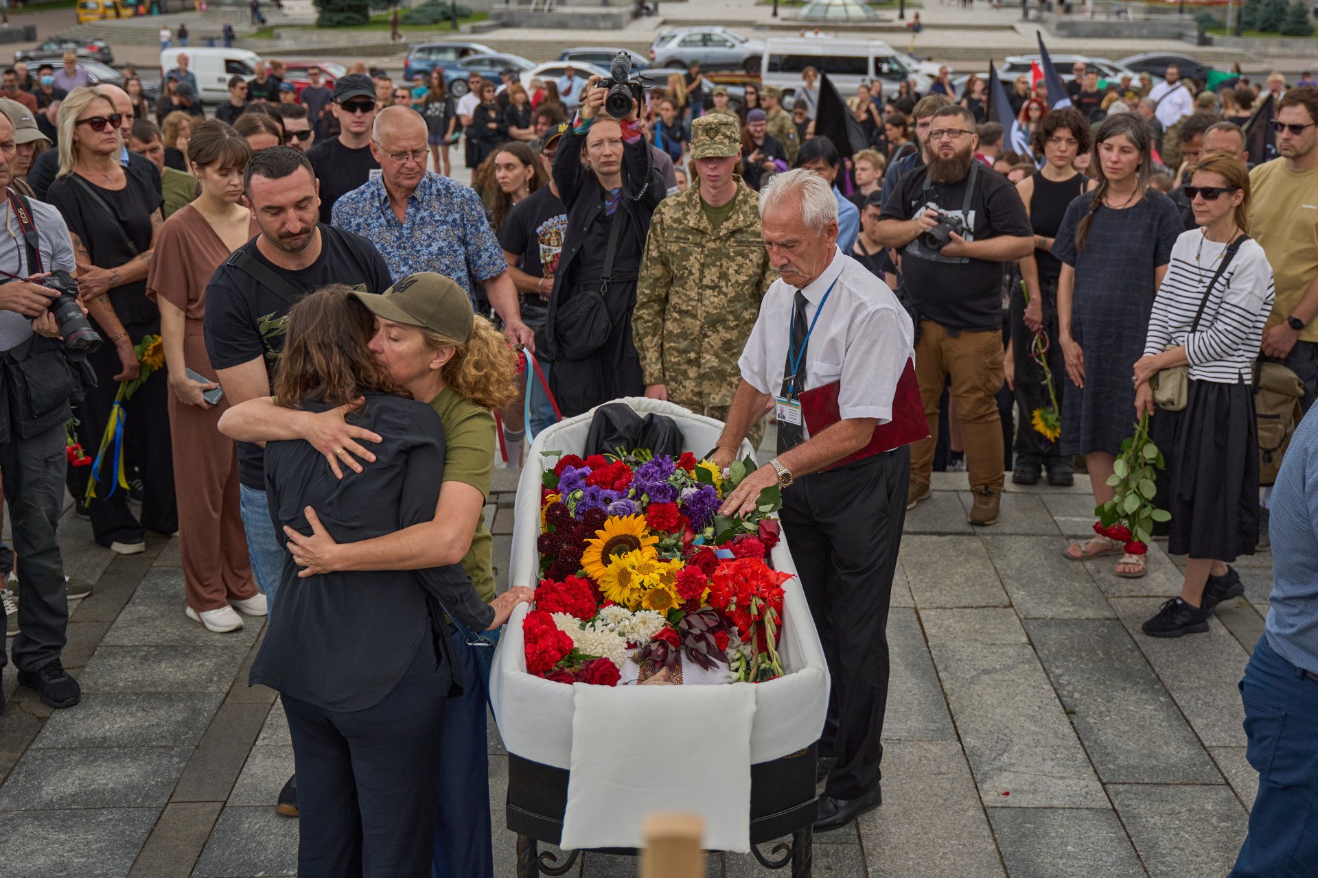 People gather around David’s coffin during the farewell ceremony honoring artist and serviceman David Chichkan at Kyiv’s Independence Square on August 18, 2025, Kyiv, Ukraine. Photo by Mykyta Shandyba/UNITED24 Media.