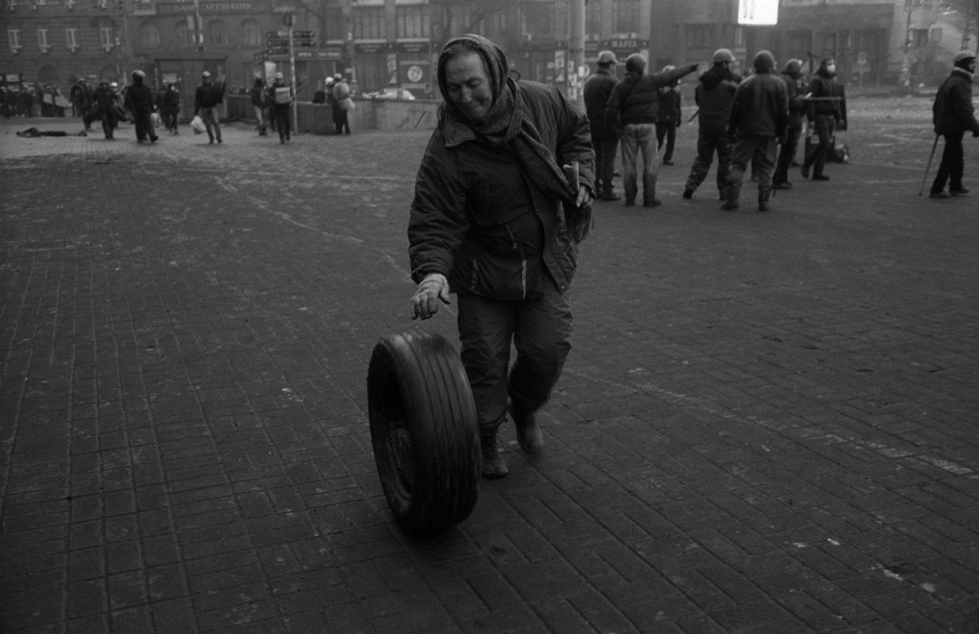 A female protester rolls a tire onto Hrushevsky Street after the retreat of anti-riot police. Kyiv, February 20, 2014. Photo: Oleksandr Glyadyelov 