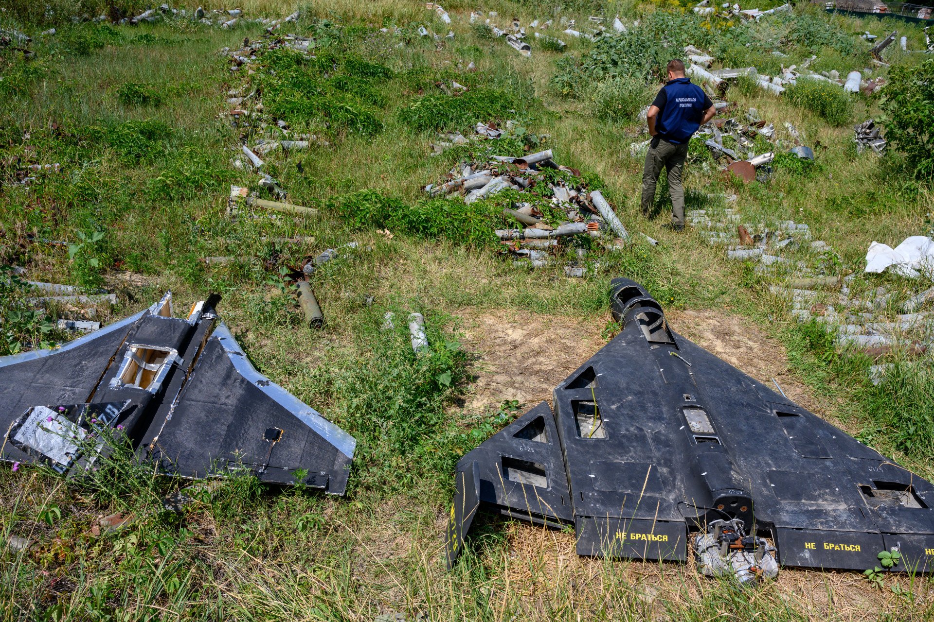 Dmytro Chubenko of the Kharkiv regional prosecutor’s office stands beside the remains of a Russian-made, Iran-designed Shahed-136 drone, known as a Geran-2 in Russia, with a cheap decoy known as a Gerbera, to the left, as the prosecutor’s office maintains a collection of Russian drones, glide bombs, missiles and rockets launched at Ukraine as evidence for eventual war crimes prosecutions against Russia, on July 30, 2025 in Kharkiv, Ukraine. Photo by Scott Peterson via Getty Images.