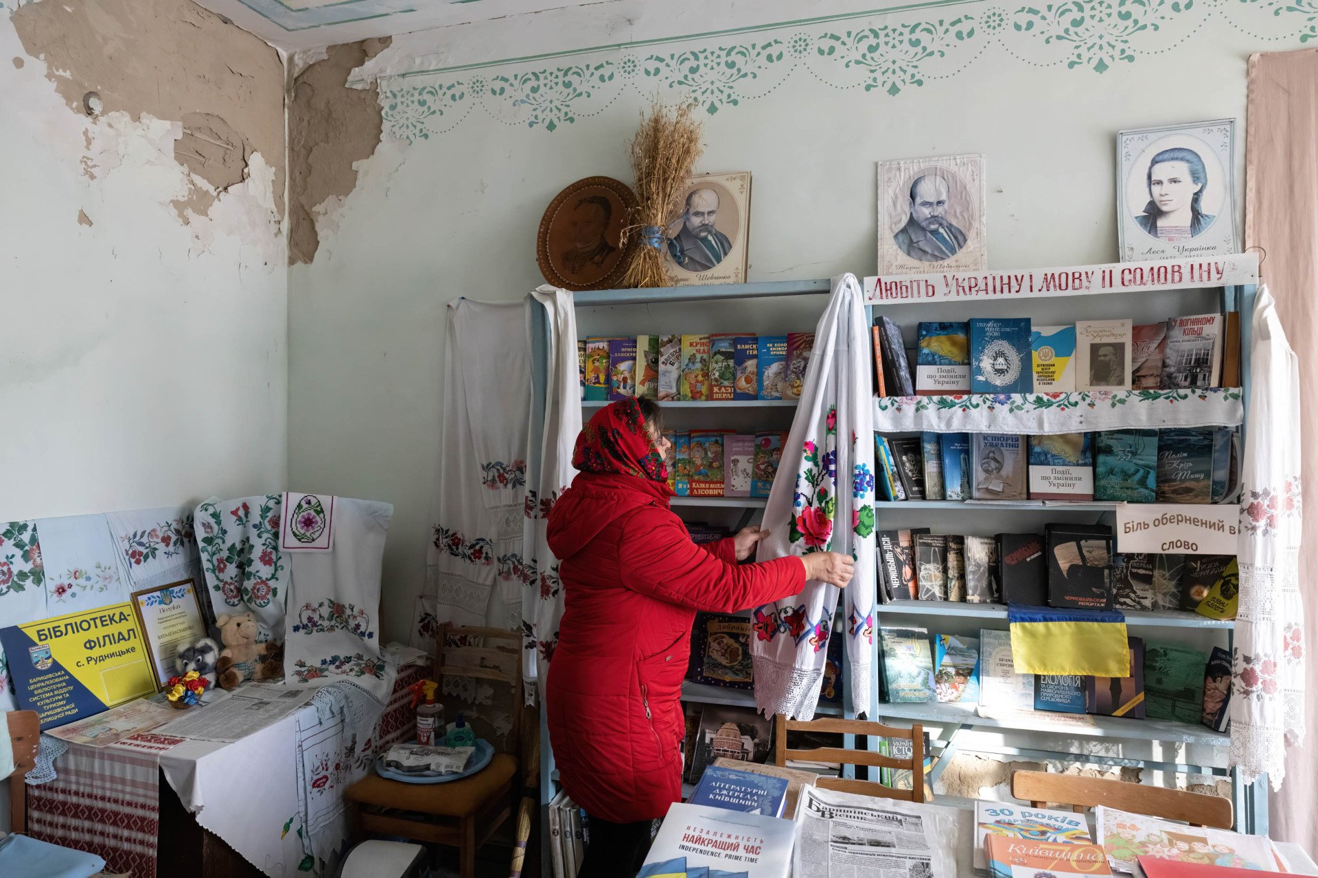 A librarian straightens the stands in the library in the village club building that was destroyed by Russian forces in the village of Rudnytske, Kyiv region in the spring of 2022, November 30, 2023. Photo by Oleksii Chumachenko/SOPA Images/LightRocket via Getty Images