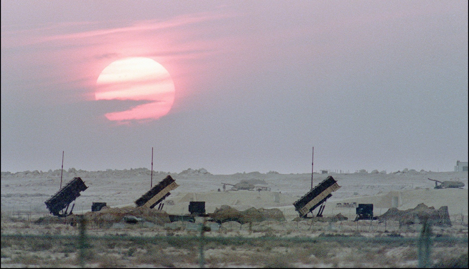 Three batteries of the US-made Patriot anti-missile missiles are lit up by the sunset on 25 January 1991 in the Saudi Arabian desert during the Gulf War against Iraq. (Source: Getty Images)