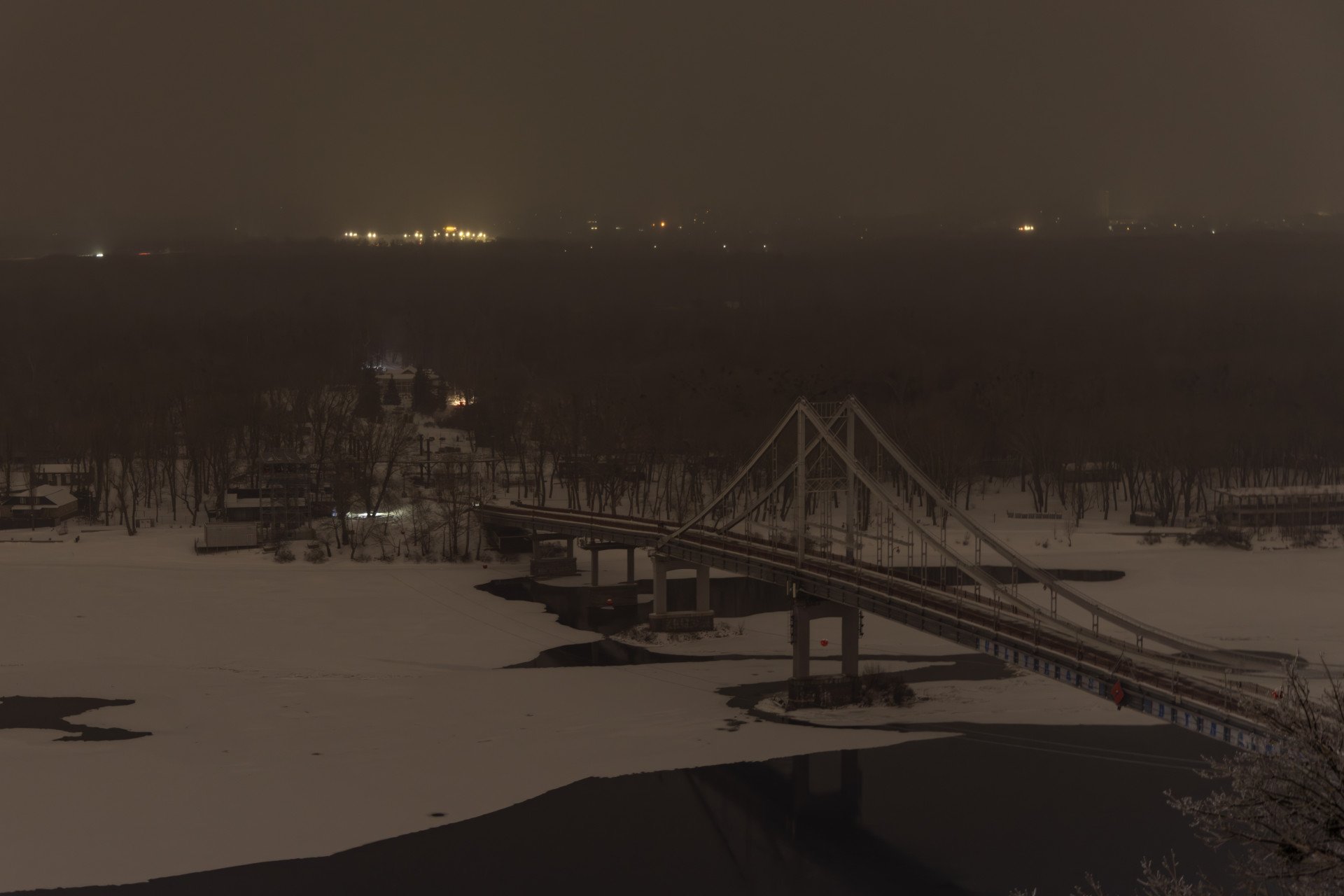 The Park Bridge across the Dnipro River to Trukhaniv Island is seen during a power outage in Kyiv on Jan. 14, 2026, as Russian drone and missile attacks disrupt electricity and heating supplies. (Photo: Getty Images)