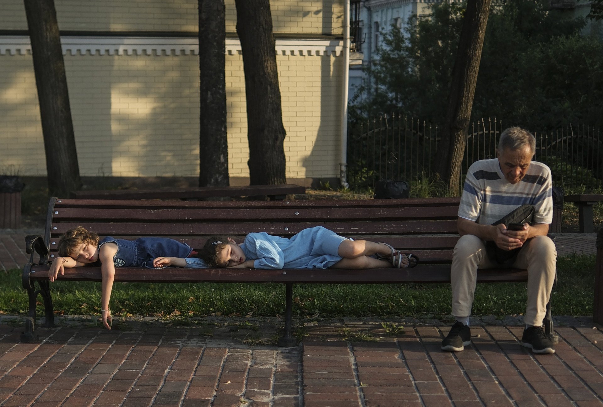 Children sleep on a bench in Kyiv, Ukraine, on August 26, 2023, as daily life continues amid Russia’s war on Ukraine. (Photo: Ercin Erturk/Anadolu Agency/Getty Images)