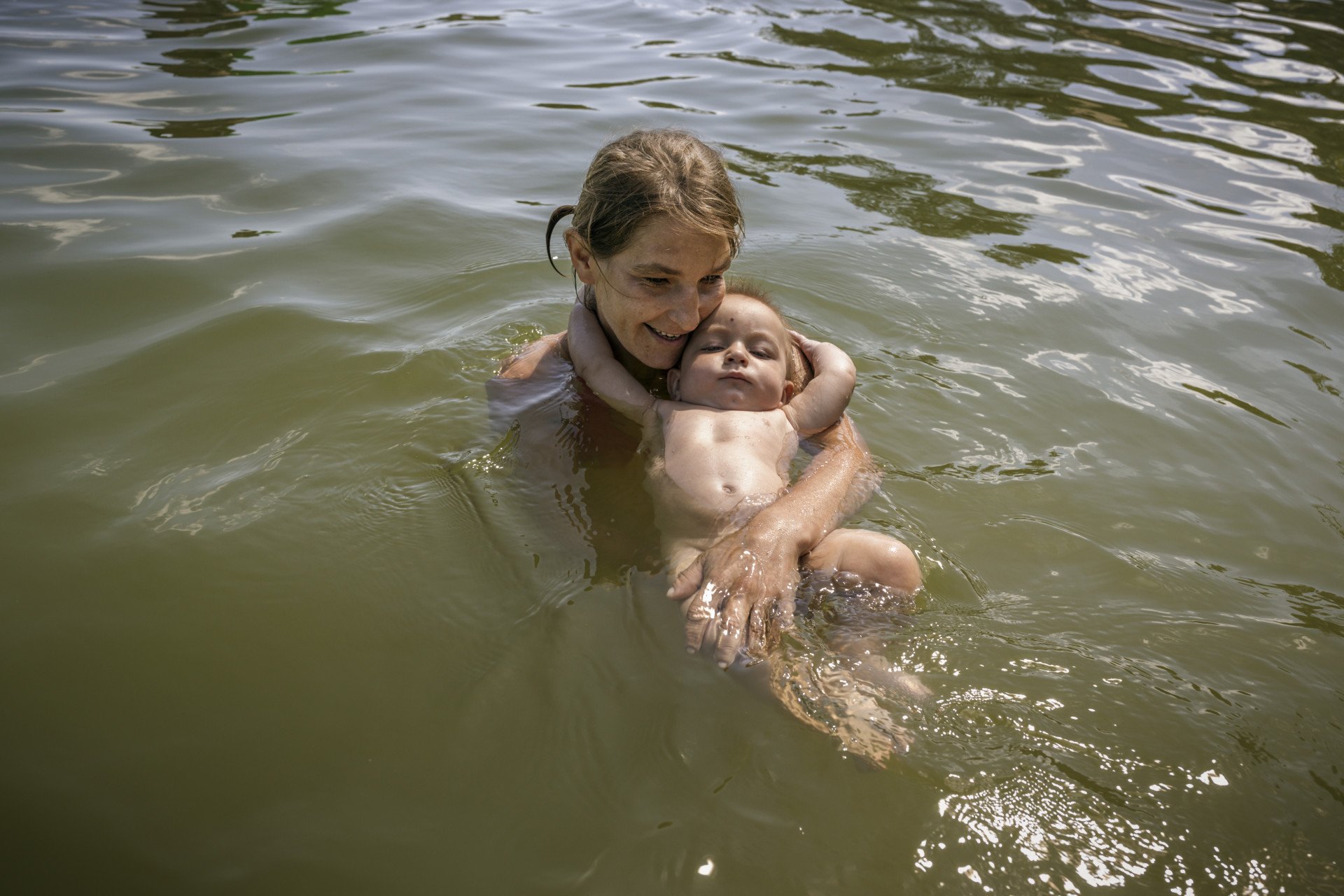 Olha Hrynyk and her nephew, Tymofii Tsvetkov, swim at a lake in the Poltava region, 2023.From the series 5K from the Frontline. (Image: Anastasia Taylor-Lind) Olha Hrynyk and her nephew, Tymofii Tsvetkov, swim at a lake in the Poltava region, 2023.From the series 5K from the Frontline. (Image: Anastasia Taylor-Lind)