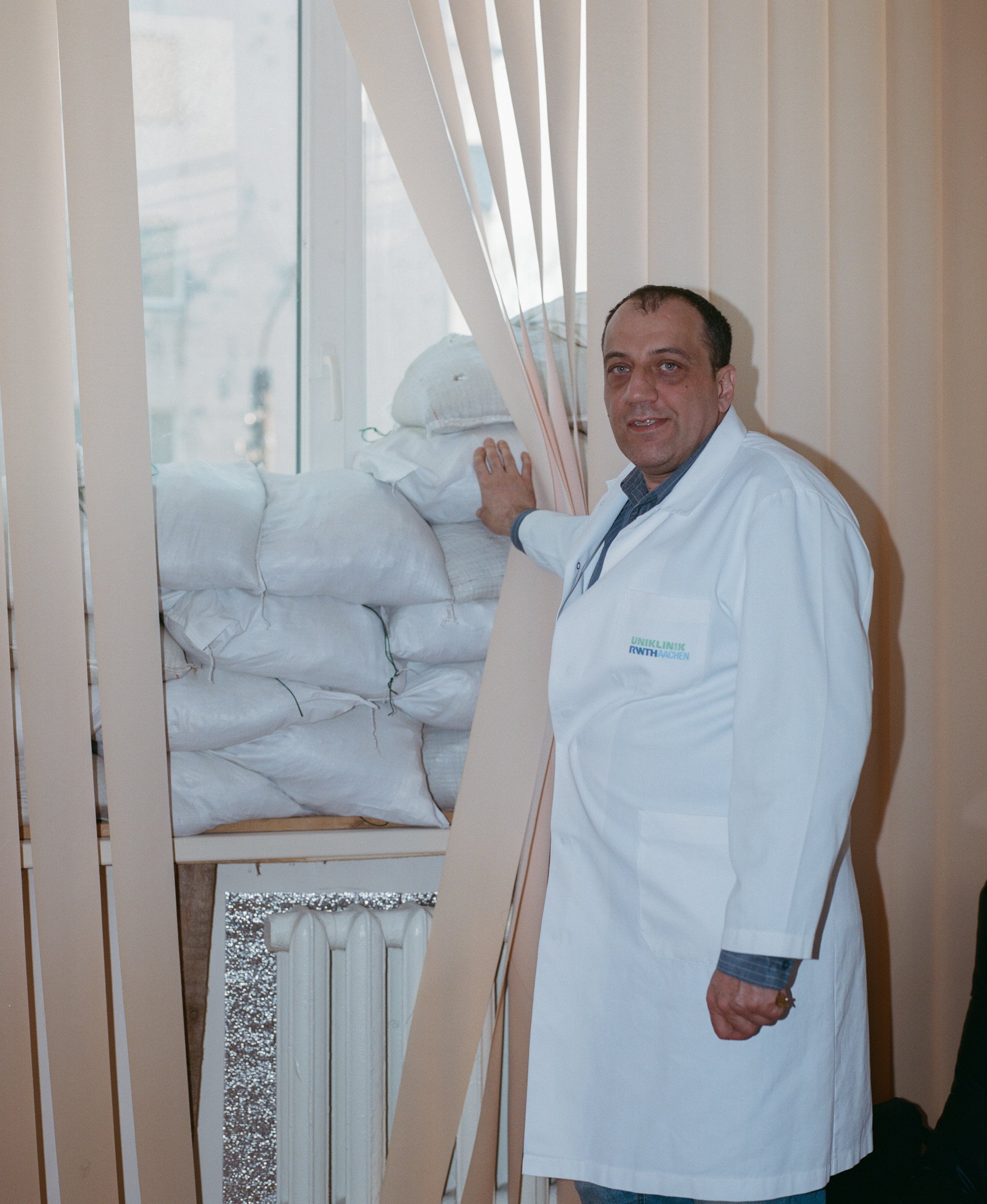 Dr. Hnilitsky pulls back his office curtain to reveal sandbags stacked for protection against Russian attacks. (Source: UNITED24 Media/ Joshua Olley) Dr. Hnilitsky pulls back his office curtain to reveal sandbags stacked for protection against Russian attacks. (Source: UNITED24 Media/ Joshua Olley)