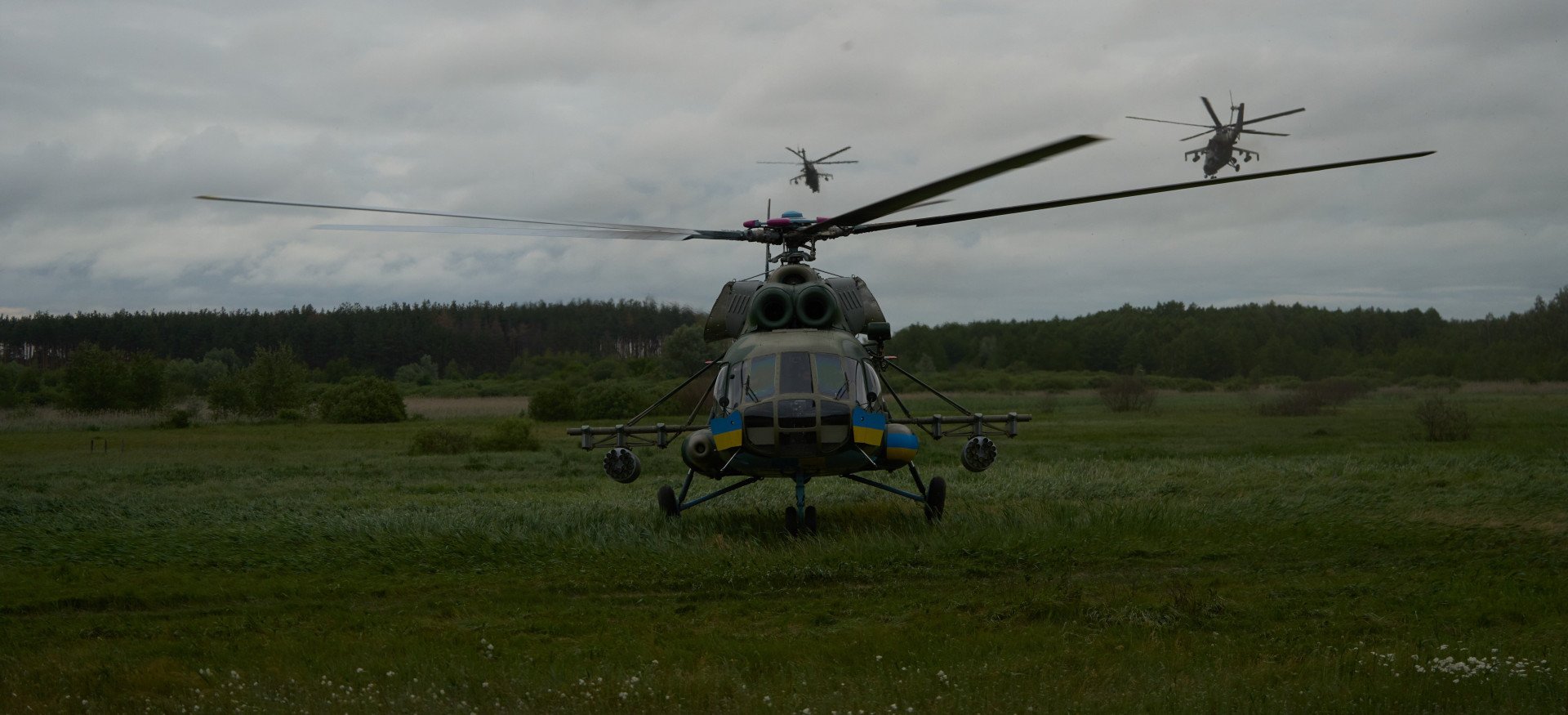 A Ukrainian Mi-8 helicopter stands as a pair of Mi-24s lift off on a combat mission, 2025. (Source: UNITED24 Media)