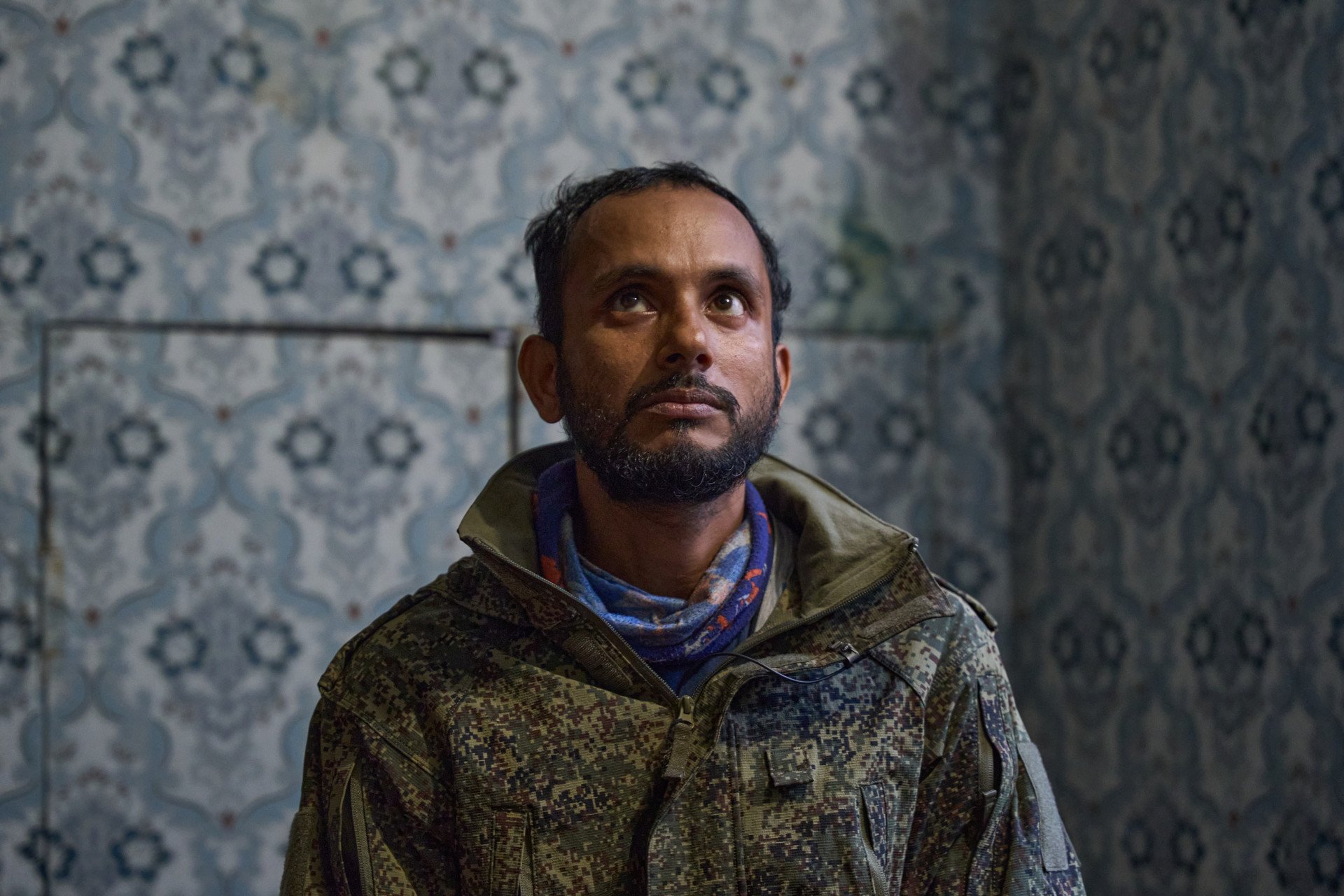 Kamrul Hasan, a 37-year-old Bangladeshi national held as a prisoner of war (POW), looks away during an interview while describing the trauma of his time in the Russian military. Forcibly conscripted into service, Hasan detailed the severe hardships and dangerous frontline conditions he endured within Russian-occupied regions of Ukraine before being captured. (Photo: Mykyta Shandyba / UNITED24 Media) Close-up portrait of Kamrul Hasan, a 37-year-old prisoner of war (POW) from Bangladesh, looking away and upward as he recounts the horrors of being a forced conscript in the Russian military within occupied Ukraine.