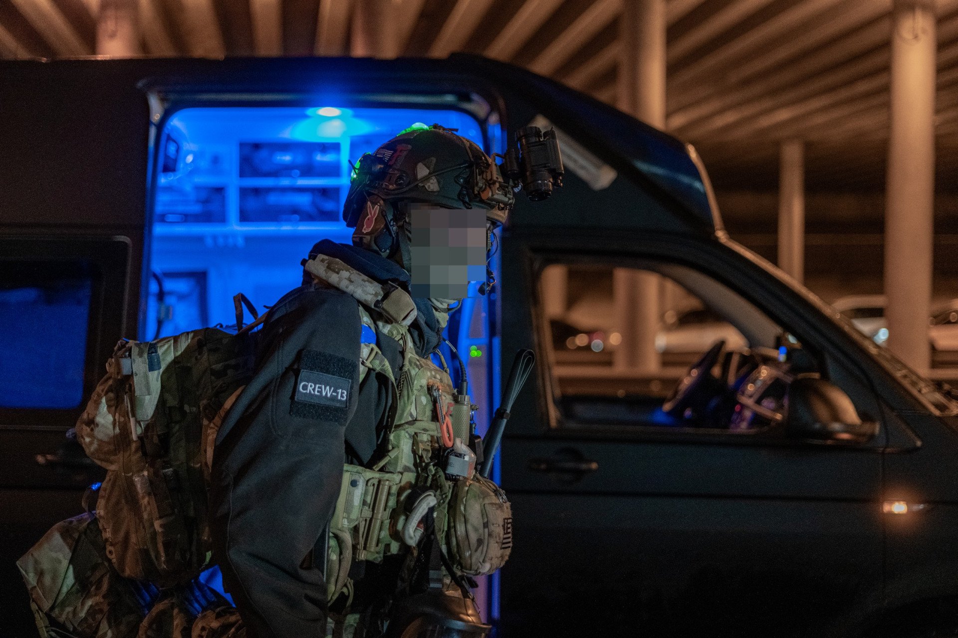 Lastivka, commander of Medical Crew 13, stands before his team’s emergency rescue vehicle at a Kyiv rendezvous point. As a massive Russian missile barrage strikes the capital, the young volunteer paramedics prepare for a high-risk overnight civilian rescue mission. Medical Crew 13 commander Lastivka standing in front of an emergency rescue vehicle at a Kyiv rendezvous point during a nighttime missile attack.