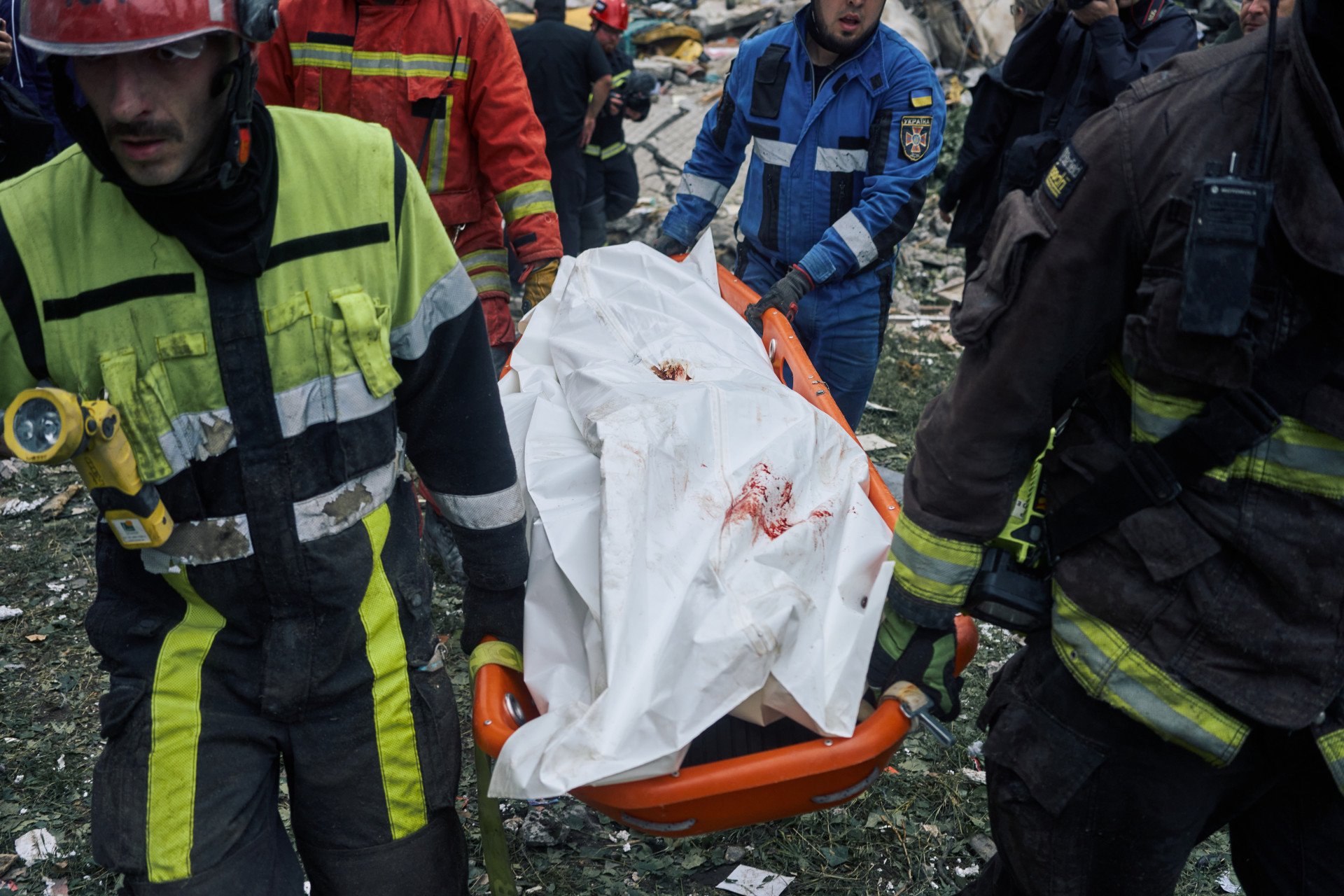 Rescue workers carry away the body of a victim killed in Russia’s missile attack, one of at least eight confirmed dead.  Kyiv, Ukraine. July 31, 2025. Photo by Josh Olley/UNITED24 Media