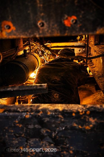 Ukrainian mechanic repairs the undercarriage of a MaxxPro armored vehicle inside a maintenance pit. (Source: 146th Separate Repair and Recovery Regiment)