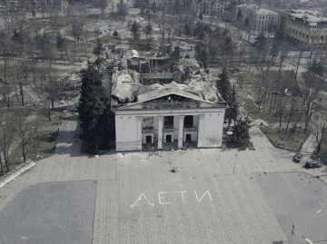 An aerial view shows the destroyed Mariupol Drama Theater in April 2022, with the word “Children” written outside the building. (Source: ABC News)
