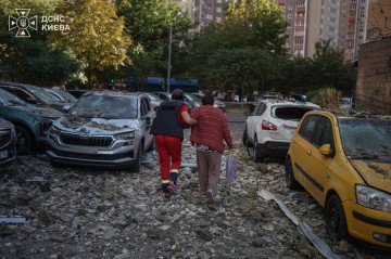 A rescuer assists a resident near damaged vehicles and debris after a Russian drone struck a residential high-rise in Kyiv on September 9, 2026. (Photo: DSNS Kyiv) A rescuer assists a resident near damaged vehicles and debris after a Russian drone struck a residential high-rise in Kyiv on September 9, 2026.