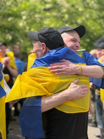 Soldados ucranianos con banderas nacionales sobre los hombros tras regresar a Ucrania, el 5 de junio de 2026. (Foto: Cuartel General de Coordinación para el Tratamiento de los Prisioneros de Guerra)
