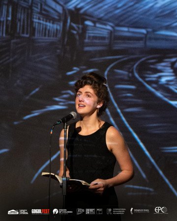 Un artista lee en voz alta en el escenario. (Fuente: Bring Kids Back UA)