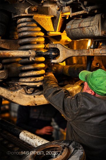 Close-up of a MaxxPro’s heavy-duty suspension system as a Ukrainian mechanic performs repairs. (Source: 146th Separate Repair and Recovery Regiment)