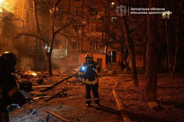 Un bombero camina entre los escombros frente a un edificio residencial dañado en Zaporizhzhia después de que un ataque con un dron ruso provocara incendios y destrucción. (Fuente: Administración Militar Regional de Zaporizhzhia)