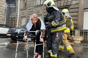SES rescuers help a woman on the site of the Russian drone strike on Kyiv on January 1, 2025. (Source: Ukrainian SES) SES rescuers help a woman on the site of the Russian drone strike on Kyiv on January 1, 2025. (Source: Ukrainian SES)