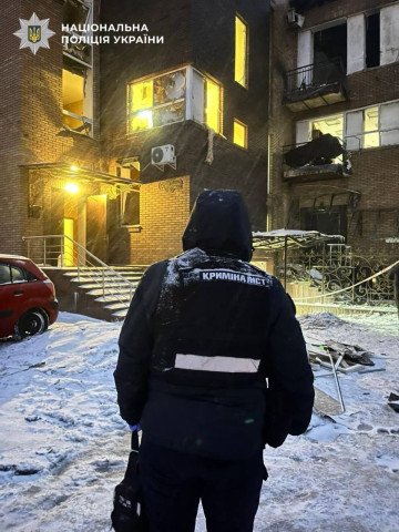 A police officer stands in front of a building with significant damage following the attack. (Photo: National Police of Ukraine)