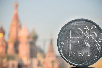 A Russian ruble coin is pictured in front of St. Basil’s cathedral in central Moscow. (Source: Getty Images)