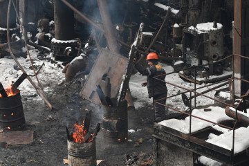 An employee stokes a fire in a barrel at a power plant of Ukrainian energy provider DTEK, which was heavily damaged during air attacks, at an undisclosed location on January 23, 2026. (Photo: Getty Images)