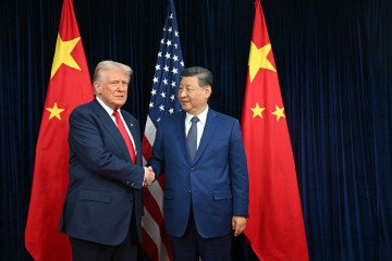 US President Donald Trump (L) and China’s President Xi Jinping shake hands as they arrive for talks at the Gimhae Air Base, located next to the Gimhae International Airport in Busan on October 30, 2025. (Source: Getty Images)