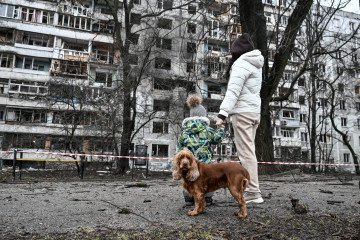 A woman with a child and a dog walks past a residential building damaged during a massive Russian missile and drone attack on Zaporizhzhia, which injured nine people. (Source: Getty Images) A woman with a child and a dog walks past a residential building damaged during a massive Russian missile and drone attack on Zaporizhzhia, which injured nine people. (Source: Getty Images)