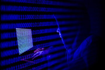 A person dressed as an internet hacker is seen with binary code displayed on a laptop screen. (Source: Getty Images) A person dressed as an internet hacker is seen with binary code displayed on a laptop screen. (Source: Getty Images)