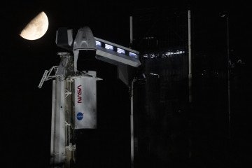 The Moon and the star Antares above a SpaceX Falcon 9 rocket. The rocket, with the Dragon spacecraft on top, is sitting on the launch pad at Kennedy Space Center. (Source: Getty Images).