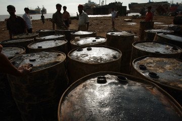 Illustrative image. Ship breakers move barrels of oil to shore from a ship that is being dismantled for scrap on July 24, 2008, in the port city of Chittagong, Bangladesh. (Source: Getty Images)