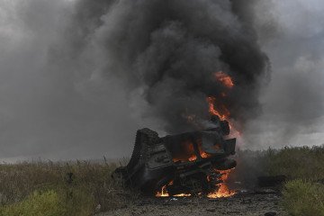 A destroyed Russian MT-LB armored vehicle burns in a field near Izium, Kharkiv region. (Source: Getty Images)