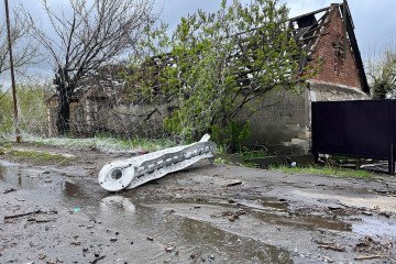 Restos de proyectil ruso y red antidrones rota frente a vivienda destruida en la ruta Kostiantynivka-Kramatorsk, zona de combate en Donetsk, Ucrania.