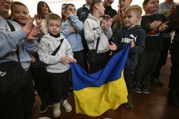 Ukraine Charges Occupation Officials in Donetsk Over Deportation of 35 Children to Russia War orphans pose with the Ukrainian flag as a group of 15 mothers and 18 children of Ukrainian soldiers who have died or gone missing in on January 10, 2026 in Lisbon, Portugal. Illustrative photo. (Source: Getty Images)