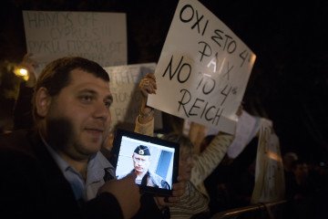 Illustrative image. A demonstrator holds an iPad with a photo of Vladimir Putin, Russia’s leader, while protesting outside the parliament in Nicosia, Cyprus, on March 21, 2013. (Source: Getty Images)