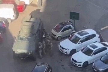 Elite KORD special forces personnel use an armored vehicle for cover in a parking lot as they prepare to storm a “Velmart” supermarket in Kyiv’s Holosiivskyi district on April 18. (Soruce: Getty Images)