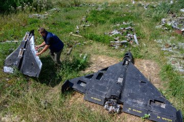 Dmytro Chubenko of the Kharkiv regional prosecutor’s office holds the remains of a Russian-made Gerbera drone, beside an Iranian-designed Shahed-136 drone, known as a Geran-2 in Russia. (Source: Getty Images)