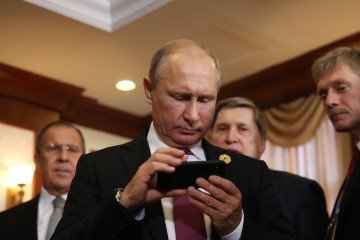 Russian leader Vladimir Putin holds an iPhone as his spokesman Dmitry Peskov looks on at the APEC Leaders Summit on November 10, 2017 in Da Nang, Vietnam. Russian leader Vladimir Putin holds an iPhone as his spokesman Dmitry Peskov looks on at the APEC Leaders Summit on November 10, 2017 in Da Nang, Vietnam.