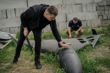 Dmytro Chubenko (R), spokesperson of the Kharkiv prosecutor, and his assistant look at a Russian Shahed drone shot down by Ukraine’s air defense forces. (Source: Getty Images)