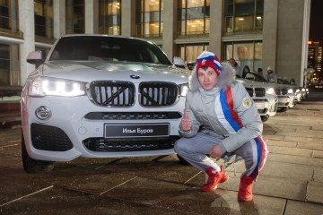 Illustrative image. Russian sportsman sits near a BMW that was gifted for his Olympic Games performance in 2018.