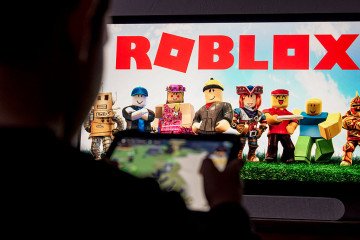 A child poses as he plays a video game on a tablet on the online game platform and game creation system Roblox. (Source: Getty Images) A child poses as he plays a video game on a tablet on the online game platform and game creation system Roblox. (Source: Getty Images)