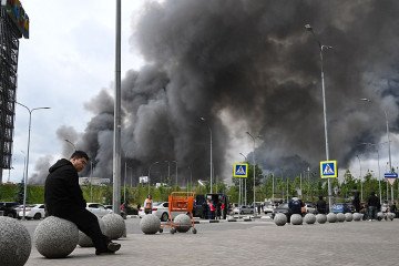 People are seen outside a shopping mall as black smoke rises from the area of the Russian oil producer Gazprom Neft’s Moscow oil refinery on the south-eastern outskirts of Moscow on June 18, 2026. (Source: Getty Images) People are seen outside a shopping mall as black smoke rises from the area of the Russian oil producer Gazprom Neft’s Moscow oil refinery on the south-eastern outskirts of Moscow on June 18, 2026. (Source: Getty Images)