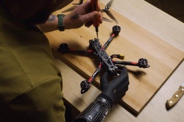 A person wearing a prosthetic arm assembles a drone. (Source: Brave1's press office)