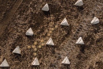 Barbed wire, dragon’s teeth anti-tank obstacles, and mines are seen along a fortification line on March 13, 2025, in the Kharkiv region, Ukraine. Barbed wire, dragon’s teeth anti-tank obstacles, and mines are seen along a fortification line on March 13, 2025, in the Kharkiv region, Ukraine.