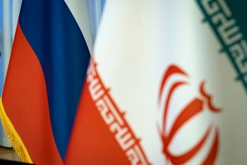 Iranian and Russian flags are pictured before a news conference at the Vahdat Hall in downtown Tehran, Iran, on June 10, 2025. (Source: Morteza Nikoubazl/NurPhoto via Getty Images)